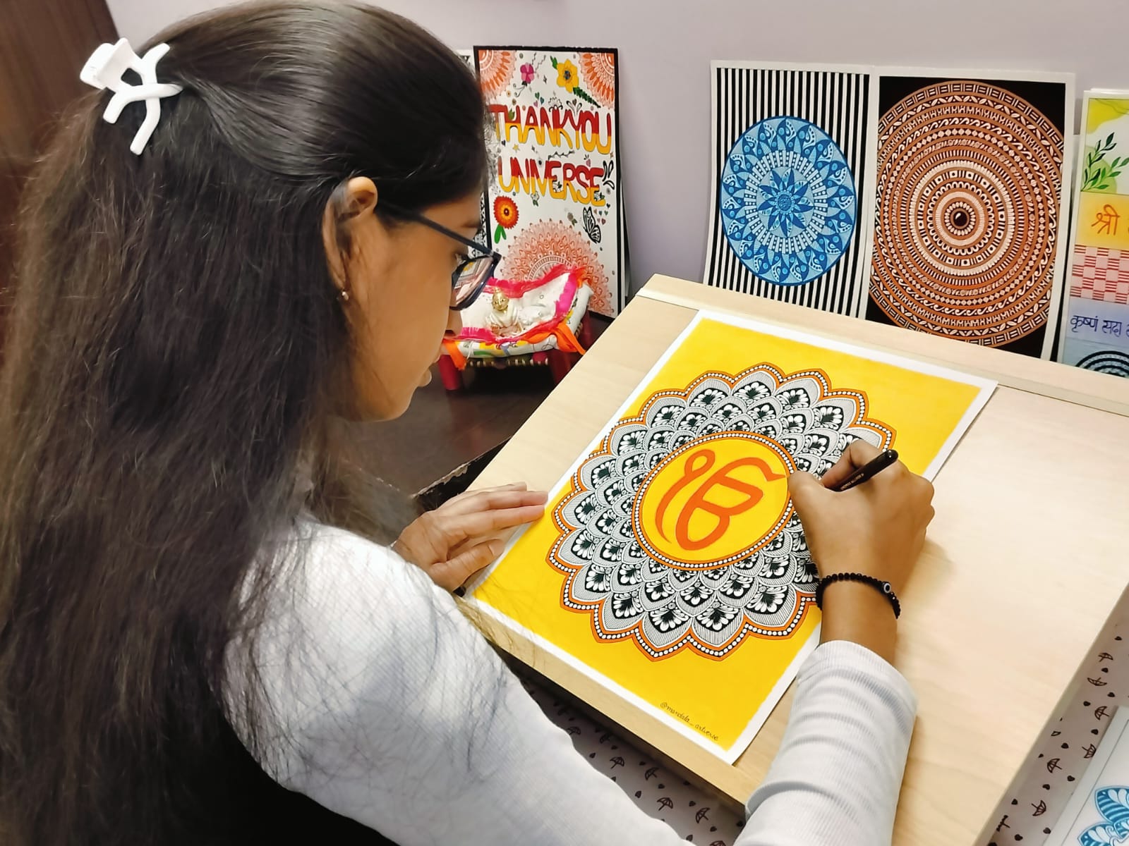 Saloni, the artist behind Mandala Artverse, hand-drawing a mandala